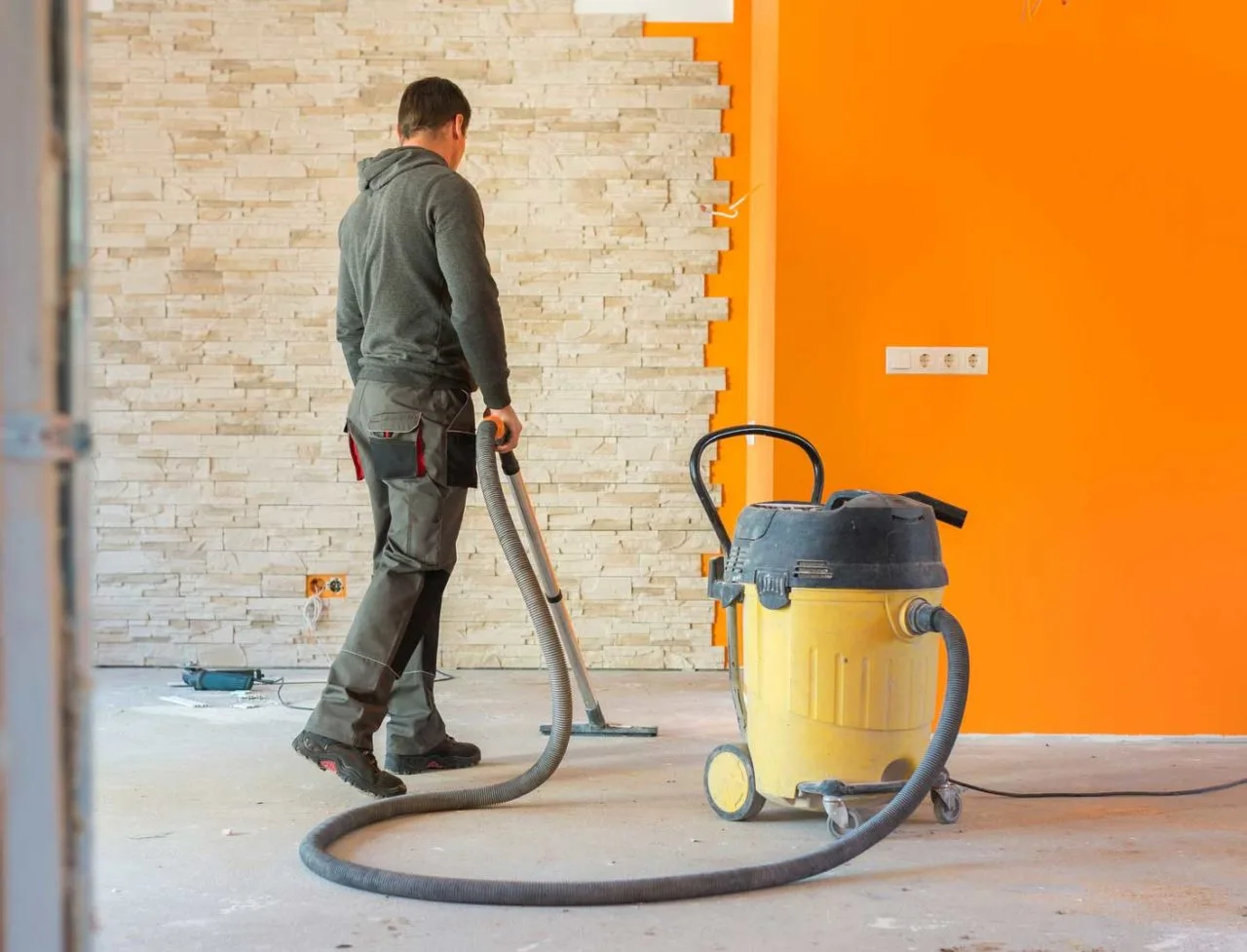 Håndværker støvsuger byggestøv med industristøvsuger efter renovering